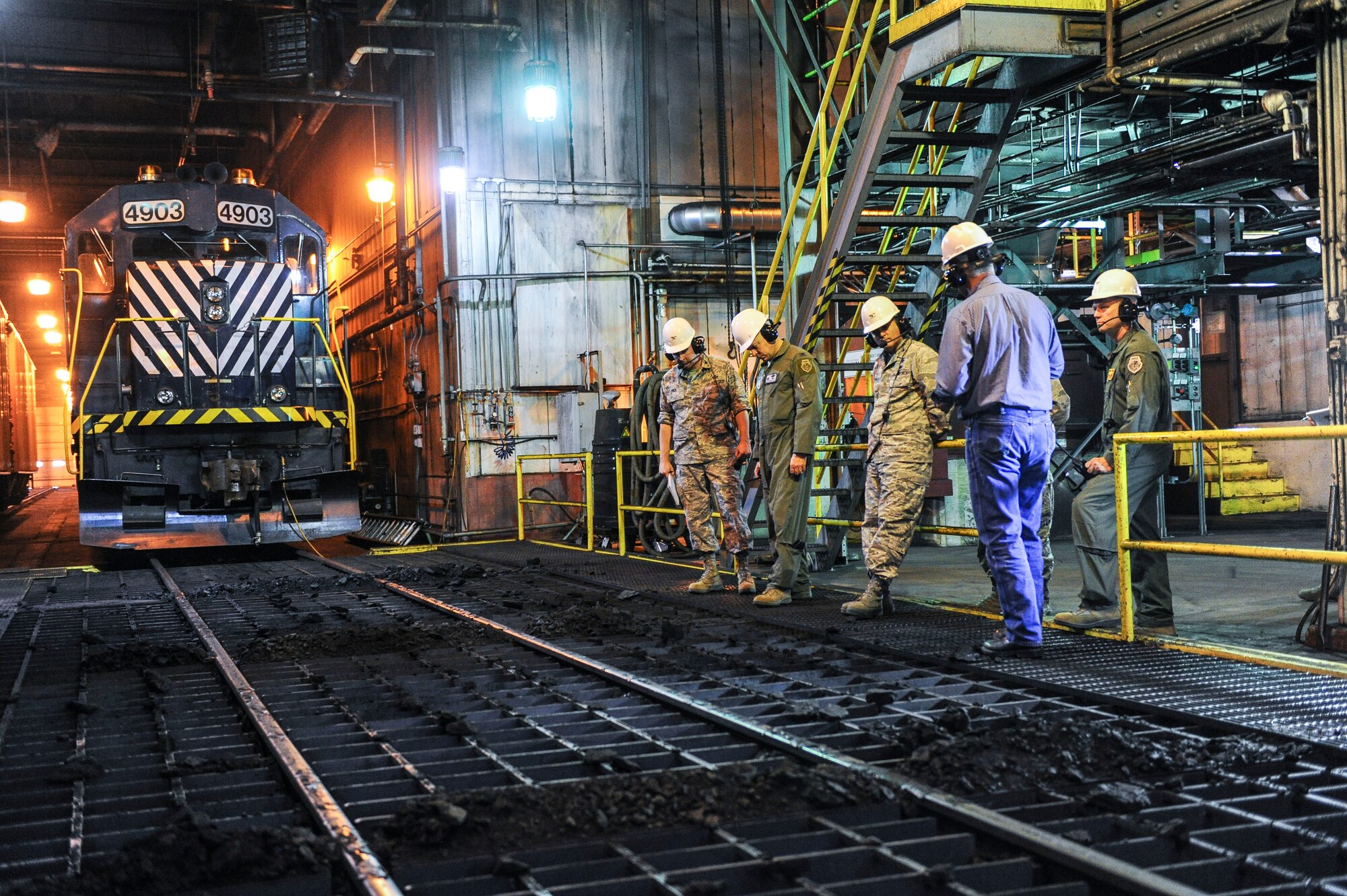 Marty Overlin, 354th Civil Engineer Squadron central heat and power superintendent, briefs 354th Fighter Wing commanders in the thaw shed during a tour of the central heat and power plant Oct. 15, 2013, Eielson Air Force Base, Alaska. Rail cars sit in the thaw shed to thaw coal and help ease the unloading process. The coal is then dropped and conveyed to bunkers which supply the boilers. (U.S. Air Force photo by Senior Airman Joshua Turner/Released) 