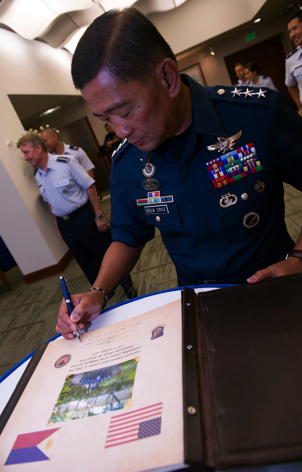 Lt. Gen. Lauro Catalino G. Dela Cruz, Commanding General of the Philippine Air Force, signs the Pacific Air Forces guest book during his visit to PACAF Oct. 16, 2013, at Joint Base Pearl Harbor-Hickam, Hawaii. This is Dela Cruz’s first visit to PACAF and was a reciprocal visit to the one Gen. Hawk Carlisle, Pacific Air Forces commander, made to the Philippines in January. The visits were an opportunity to exchange views on bilateral, regional, and global issues reflecting common values and interests, and to demonstrate the strength of the partnership between the U.S. and Philippine Air Forces. (U.S. Air Force photo/Staff Sgt. Nathan Allen) 