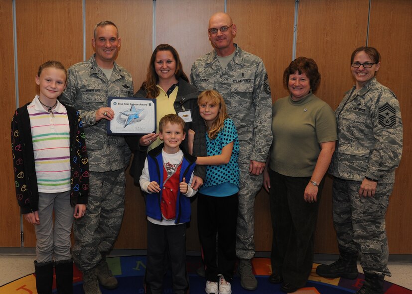 Col. Brian Newberry, 92nd Air Refueling Wing commander, his wife, Jill Newberry, and Chief Master Sgt. Wendy Hansen, 92nd ARW command chief, present the Blue Star Spouse Award to Theresa Turner at Fairchild Air Force Base, Wash., Oct. 16, 2013.  Theresa's husband, Chief Master Sgt. Lance Turner, 92nd Medical Group superintendent, and their children were present to help congratulate her.  Ms. Turner was presented the award for her excellent support of Fairchild families, including her significant support as a volunteer at Michael Anderson Elementary and leading family chapel programs.  Anyone interested in nominating someone for the Blue Star Spouse Award should contact their squadron commander.  (U.S. Air Force photo by Airman 1st Class Sam Fogleman/Released)