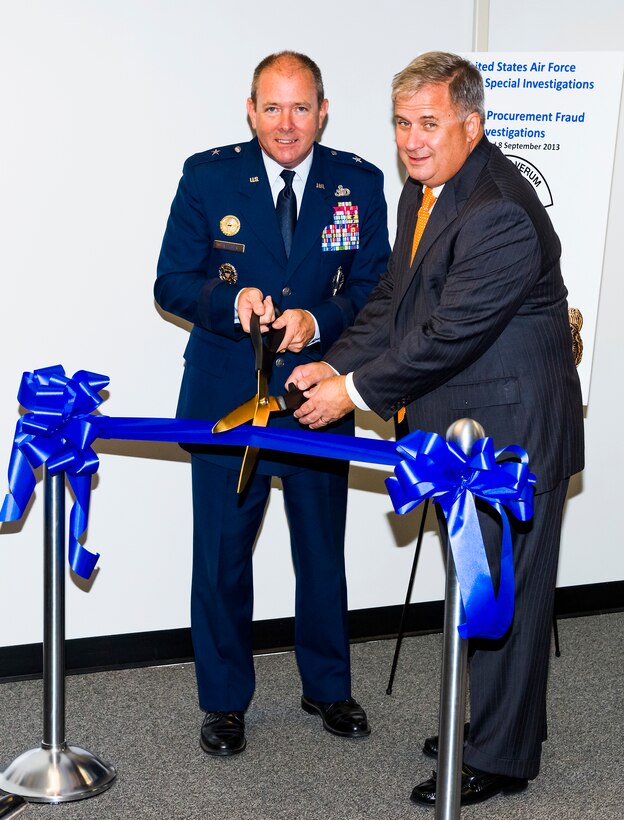 Brig. Gen. Kevin J. Jacobsen, Air Force Office of Special Investigations commander, left, and Mr. Bob Kwalwasser, OSI Office of Procurement Fraud director, prepare to cut the ribbon during the PF office activation ceremony. In creating this new office, OSI is moving forward with three main objectives: to refocus the mission; to align OSI with their primary customer, The Assistant Secretary of the Air Force/Acquisition; and to centralize and define procurement fraud investigations across the Air Force.  (U.S. Air Force photo/Mike Hastings)