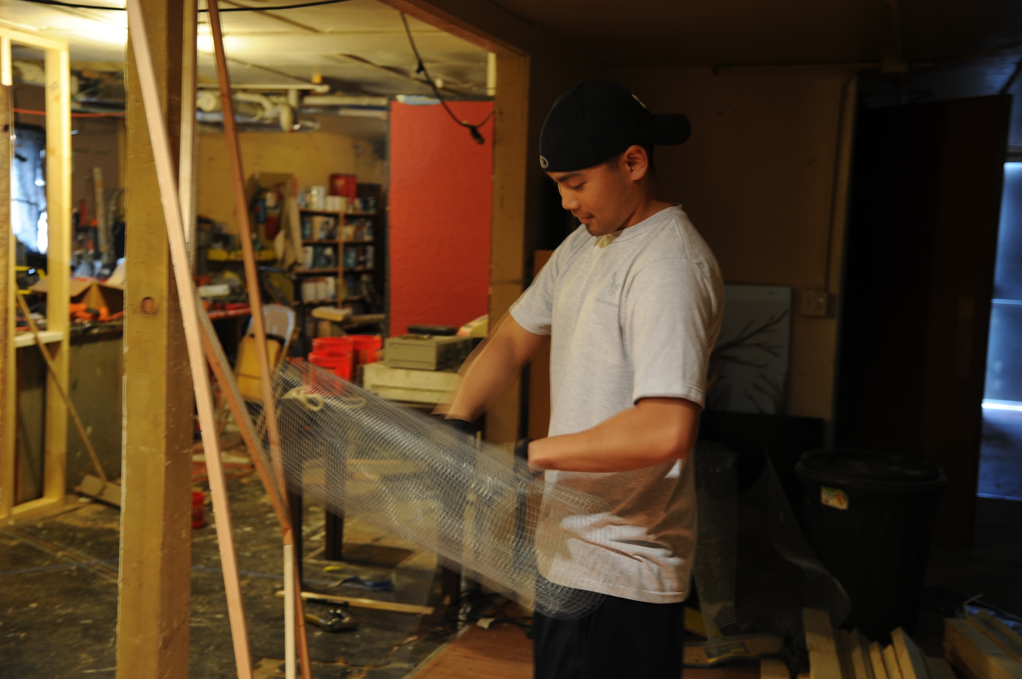 Senior Airman Vince Feliciano, 341st Missile Maintenance Squadron technician, unrolls screen wire to be put over a door he built.  He was one of nearly 50 Airmen who signed up to volunteer at the Montana Actor’s Theater haunted house, which opened Oct. 17 and will run through Nov. 2.  (U.S. Air Force photo/Senior Airman Cortney Paxton)
