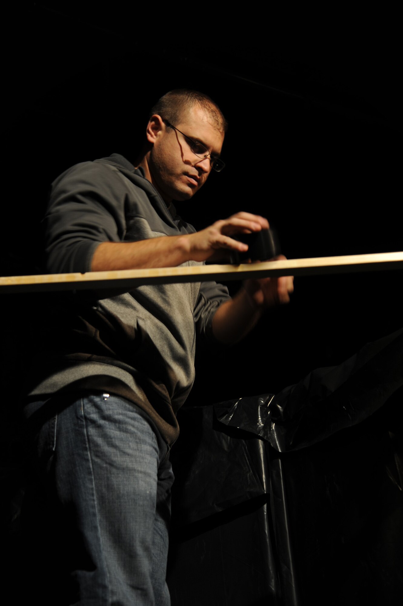 Staff Sgt. Jon Sestito, 341st Missile Maintenance Squadron data analyst, rips black tape to cover exposed wires during the set up and rehearsal of the Montana Actor’s Theater haunted house in Great Falls, Mont.  Several volunteers gathered at the MAT Oct. 12 to set up in preparation for the haunted house’s opening Oct. 17.  (U.S. Air Force photo/Senior Airman Cortney Paxton)