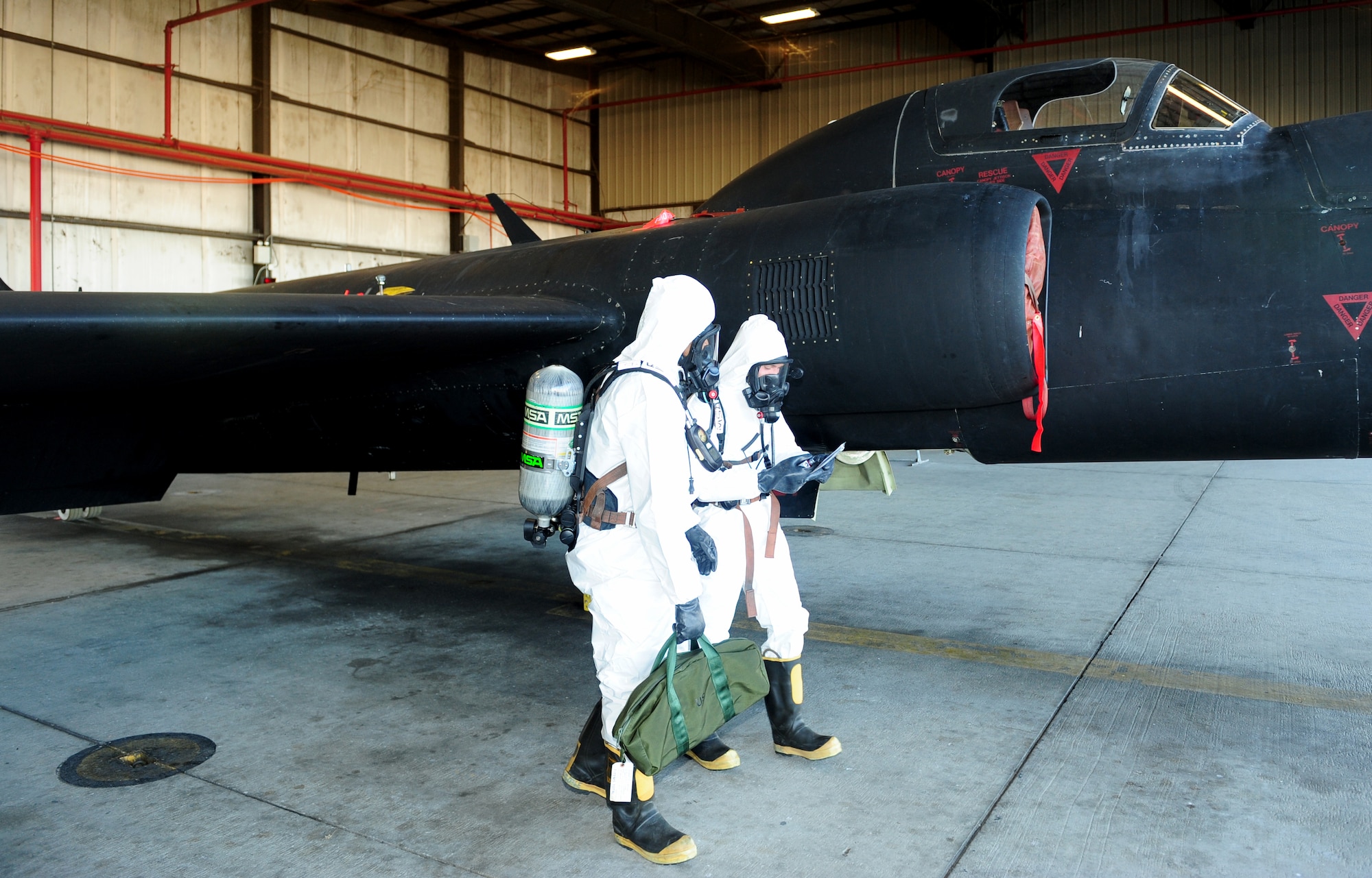 Staff Sgt. Brian Hart (front), 9th Maintenance Squadron aircraft fuels systems technician, performs inspections on a U-2 Dragon Lady with Senior Airman James Everson, 9th Maintenance Squadron aircraft fuels systems technician, Oct. 11, 2013, at Beale Air Force Base, Calif. The hazardous materials suits protect the Airmen from exposure to hydrazine. (U.S. Air Force photo by Airman 1st Class Bobby Cummings/Released)