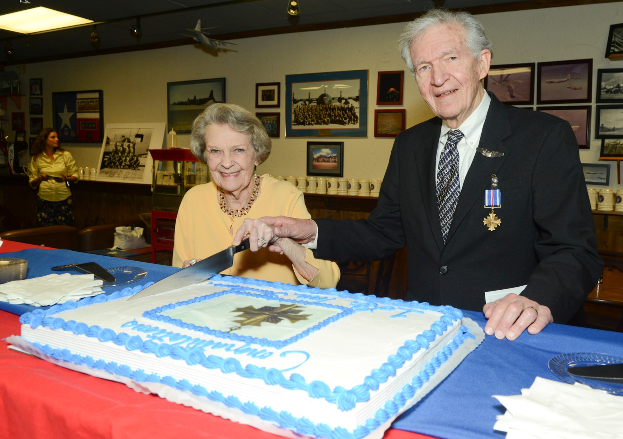 Thomas P. Faulkner, a former pilot and 1st. Lt. of the U.S. Army Air Forces’ 15th Air Force, in Italy during WWII cuts the Distinguished Flying Cross cake with his wife in celebration of his award for his 28th mission at the age of 19. Faulkner, now 88 received his DFC 68 years after the fact at the 136th Airlift Wing, Naval Air Station Fort Worth Joint Reserve Base, Texas, Sept. 19, 2013. (Air National Guard photo by Senior Master Sgt. Elizabeth Gilbert/released)