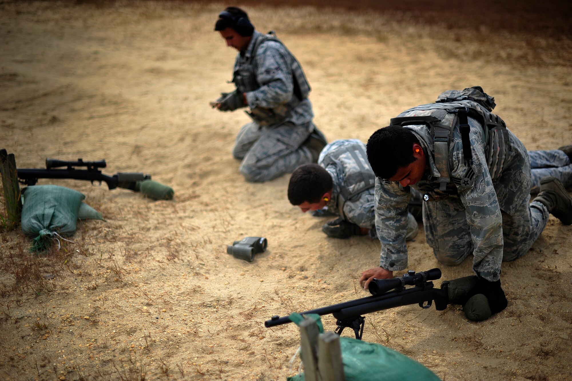 JOINT BASE MCGUIRE-DIX-LAKEHURST, N.J. -- Three close precision engagement course candidates assigned to the 621st Contingency Response Wing finish an exhausting bear crawl to a firing position on a firing range here Oct. 3.  The candidates were participating in an in-house 10-day CPEC indoctrination and qualification course to prepare them for the more rigorous 19-day U.S. Air Force CPEC course at Fort Bliss, Texas.  (U.S. Air Force photo by Tech. Sgt. Parker Gyokeres)