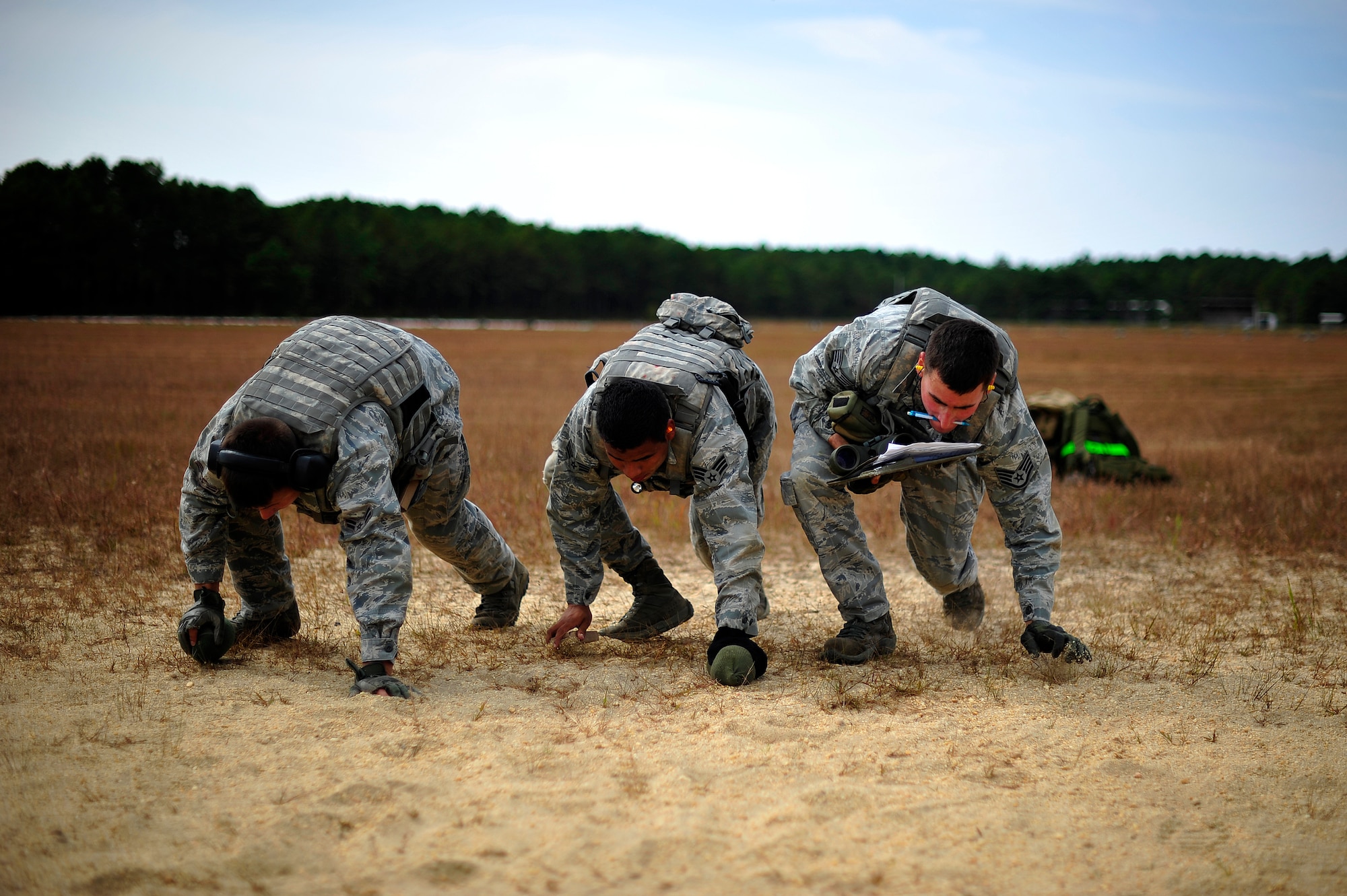 JOINT BASE MCGUIRE-DIX-LAKEHURST, N.J. -- Three close precision engagement course candidates assigned to the 621st Contingency Response Wing bear crawl towards a firing position at a firing range here Oct. 3.  The candidates were participating in an in-house 10-day CPEC indoctrination and qualification course to prepare them for a more rigorous 19-day U.S. Air Force CPEC course at Fort Bliss, Texas.  (U.S. Air Force photo by Tech. Sgt. Parker Gyokeres)