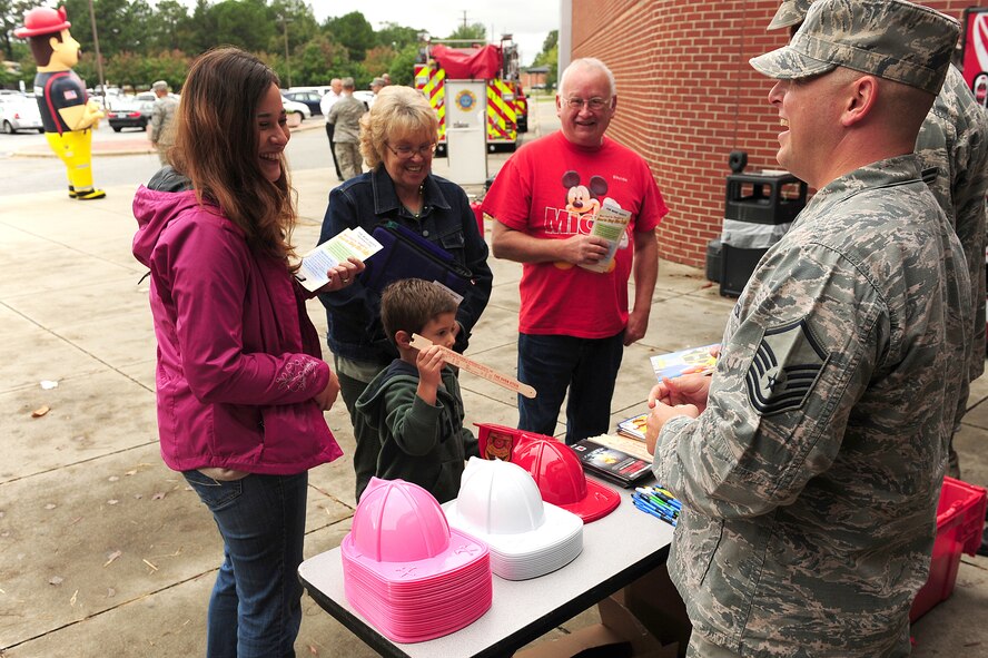 Members of the 4th Civil Engineer Squadron distribute educational items during a fire prevention demonstration at Seymour Johnson Air Force Base, N.C., Oct. 11, 2013.  The 4th CES setup several displays to help raise awareness of possible kitchen fires during Fire Prevention Week, Oct. 7-11.  (U.S. Air Force photo by Airman 1st Class Brittain Crolley)
