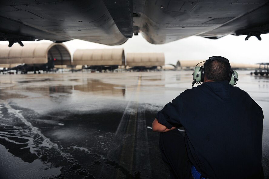 U.S. Air Force Airman 1st Class Daryl McCarthy, 4th Aircraft Maintenance Squadron crew chief, crouches under an F-15E Strike Eagle at Seymour Johnson Air Force Base, N.C., Oct. 10, 2013.  While at home station, the 4th Fighter Wing fighter squadrons conduct training missions to maintain the readiness of aircrew and ground crew.   (U.S. Air Force photo by Airman 1st Class Brittain Crolley)