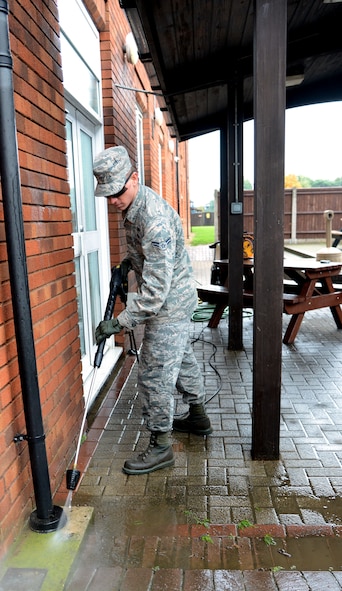 U.S. Air Force Airman 1st Class Joshua Foxworth, 100th Civil Engineer Squadron emergency management journeyman from Chipley, Fla., power washes a patio Oct. 16, 2013, outside Dormitory 108 on RAF Mildenhall, England. Airmen from Dormitory 108 power washed, raked, mowed grass and did an overall cleaning of the exterior and interior of their dorm.  The Airmen cleaned in preparation for the Dormitory of the Quarter inspection. (U.S. Air Force photo by Airman 1st Class Kelsey Waters/Released)