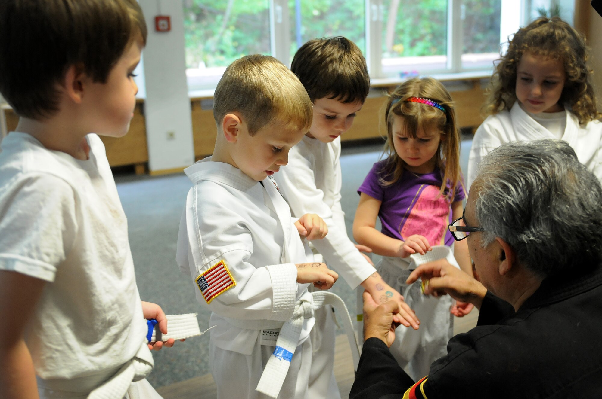 Richard Vasquez, Karate Tech class instructor, rewards students for correctly answering karate terminology questions, Oct. 8, 2013, Vogelweh, Germany. The Karate Tech class helps gain self-discipline, experience in martial arts and enhance physical fitness to KMC members. (U.S. Air Force photo/Airman 1st Class Holly Mansfield)