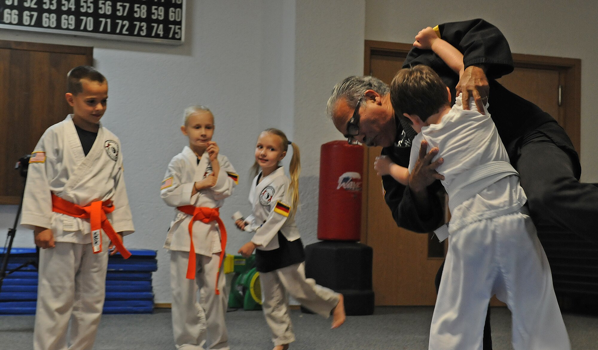 Richard Vasquez, Karate Tech class instructor, grapples with karate students during a Sumo wrestling demonstration, Oct. 8, 2013, Vogelweh, Germany. The Karate Tech class helps gain self-discipline, experience in martial arts and enhance physical fitness to KMC members. (U.S. Air Force photo/Airman 1st Class Holly Mansfield)