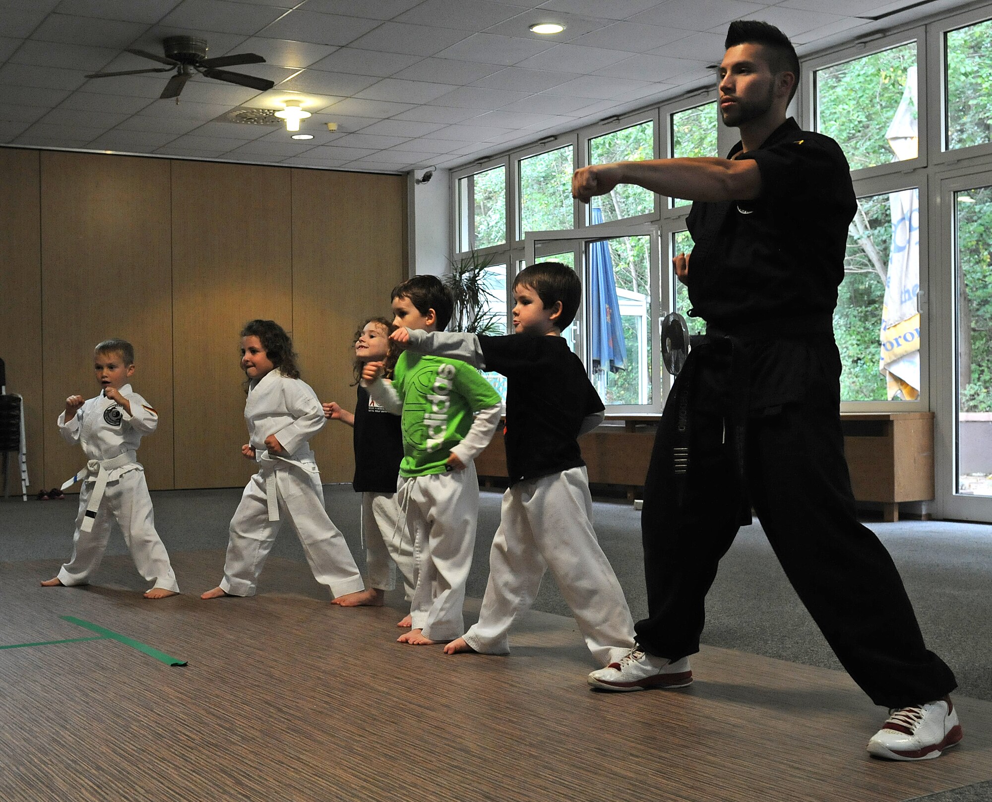 Jorge Ordonio Jr., Karate Tech class instructor, does karate moves with KMC children, Oct. 8, 2013, Vogelweh, Germany. The Karate Tech class helps gain self-discipline, experience in martial arts and enhance physical fitness to KMC members. (U.S. Air Force photo/Airman 1st Class Holly Mansfield) 