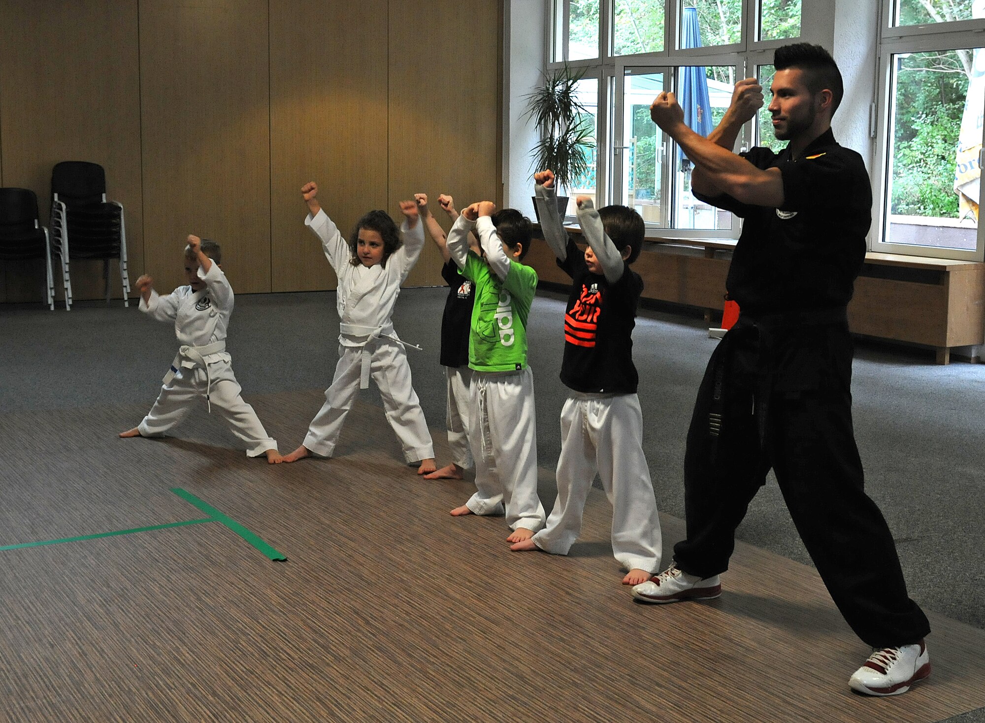 Jorge Ordonio Jr., Karate Tech class instructor, does karate moves with KMC children, Oct. 8, 2013, Vogelweh, Germany. The Karate Tech class helps gain self-discipline, experience in martial arts and enhance physical fitness to KMC members. (U.S. Air Force photo/Airman 1st Class Holly Mansfield) 