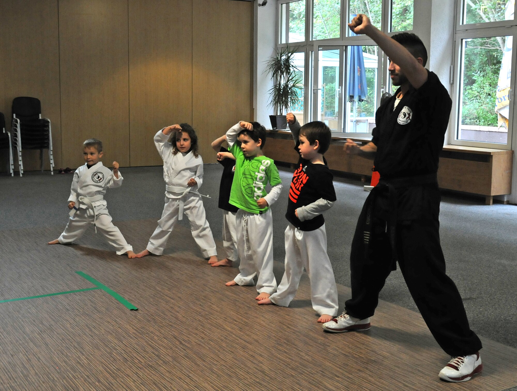 Jorge Ordonio Jr., Karate Tech class instructor, does karate moves with KMC children, Oct. 8, 2013, Vogelweh, Germany. The Karate Tech class helps gain self-discipline, experience in martial arts and enhance physical fitness to KMC members. (U.S. Air Force photo/Airman 1st Class Holly Mansfield) 