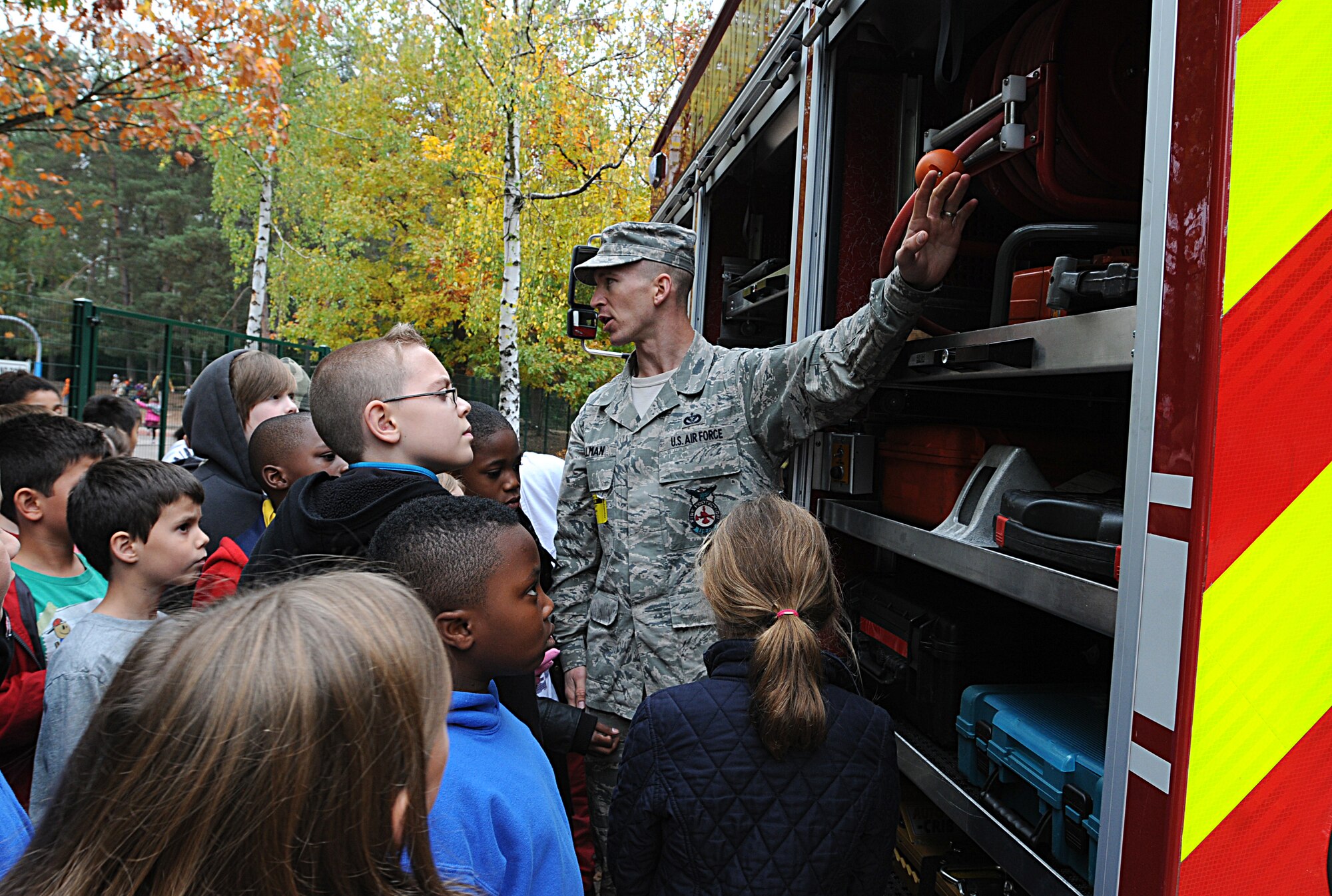 Staff Sgt. Gregory Ullman, 86th Civil Engineer Squadron fire prevention inspector, teaches students about the different parts of a fire truck during Fire Prevention Week, Oct. 9, 2013, Landstuhl, Germany. Sparky the fire dog and KMC firefighters held briefings and conducted live fire extinguisher training at KMC elementary schools, the Ramstein Express gas station and Enlisted Club. (U.S. Air Force photo/Airman 1st Class Holly Mansfield)