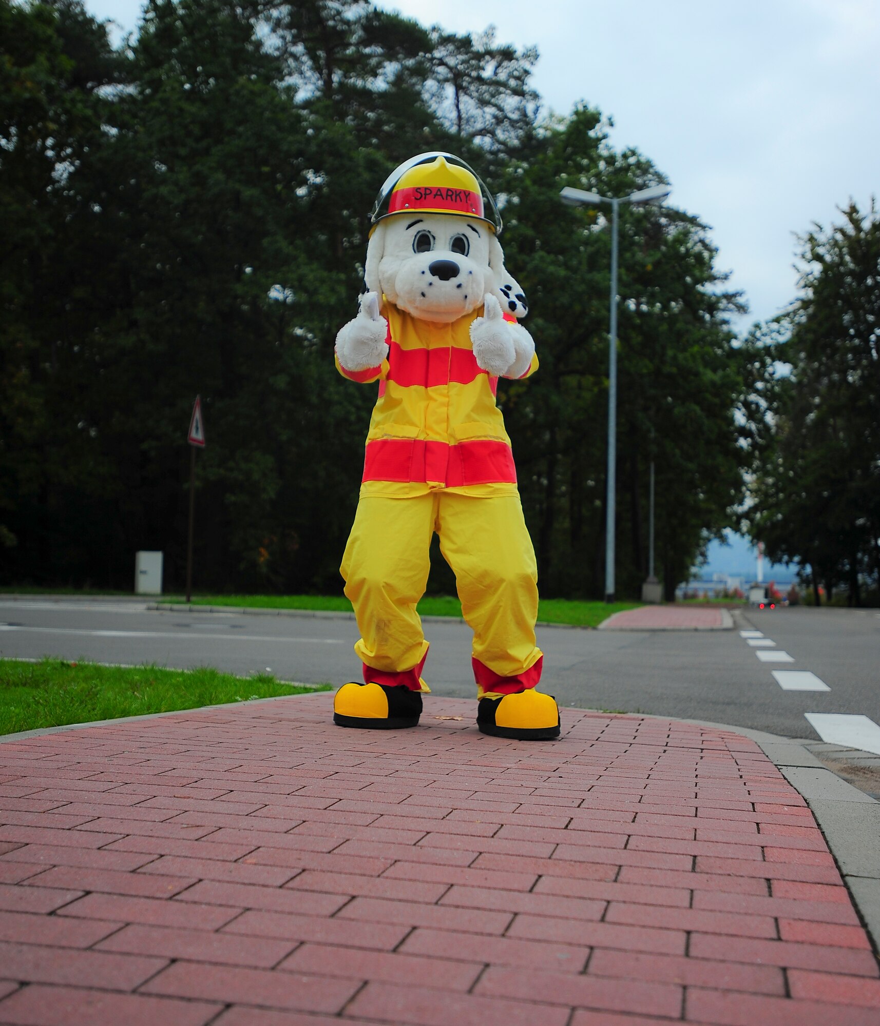 Sparky the fire dog waves to passing drivers at the Ramstein Express gas station during Fire Prevention Week, Oct. 8, 2013, Ramstein Air Base, Germany. Sparky and KMC firefighters held briefings and conducted live fire extinguisher training at KMC elementary schools, the Ramstein Express gas station and Enlisted Club. (U.S. Air Force photo/Airman 1st Class Michael Stuart)