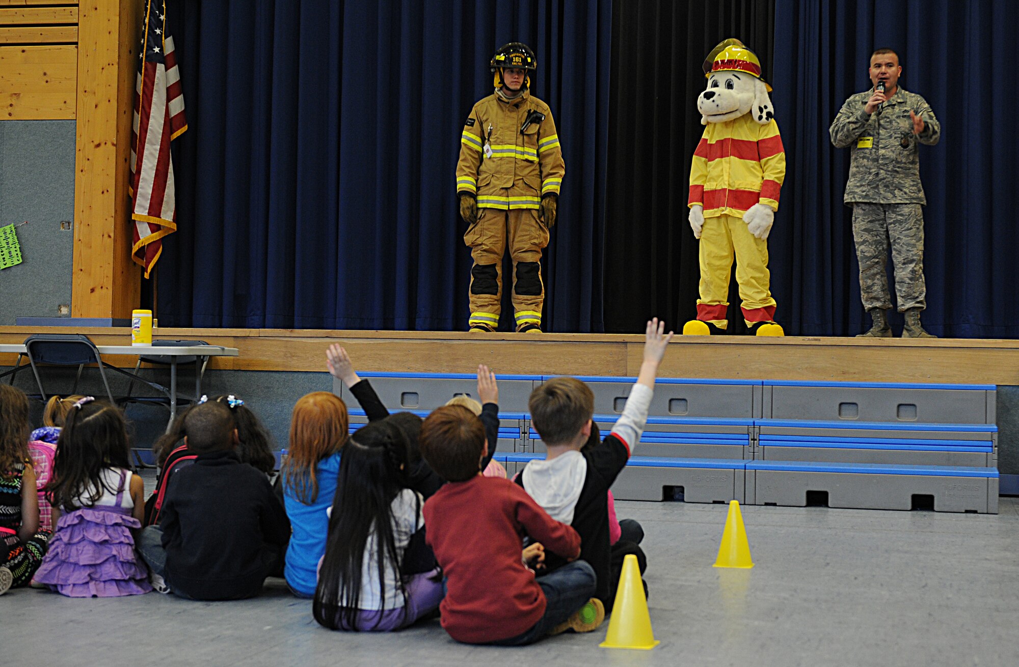 Ramstein Elementary School first graders ask questions about how to prevent kitchen fires and escape plans for their families during Fire Prevention Week, Oct. 7, 2013, Ramstein Air Base, Germany. Sparky the fire dog and KMC firefighters held briefings and conducted live fire extinguisher training at KMC elementary schools, the Ramstein Express gas station and Enlisted Club. (U.S. Air Force photo/Airman 1st Class Holly Mansfield)
