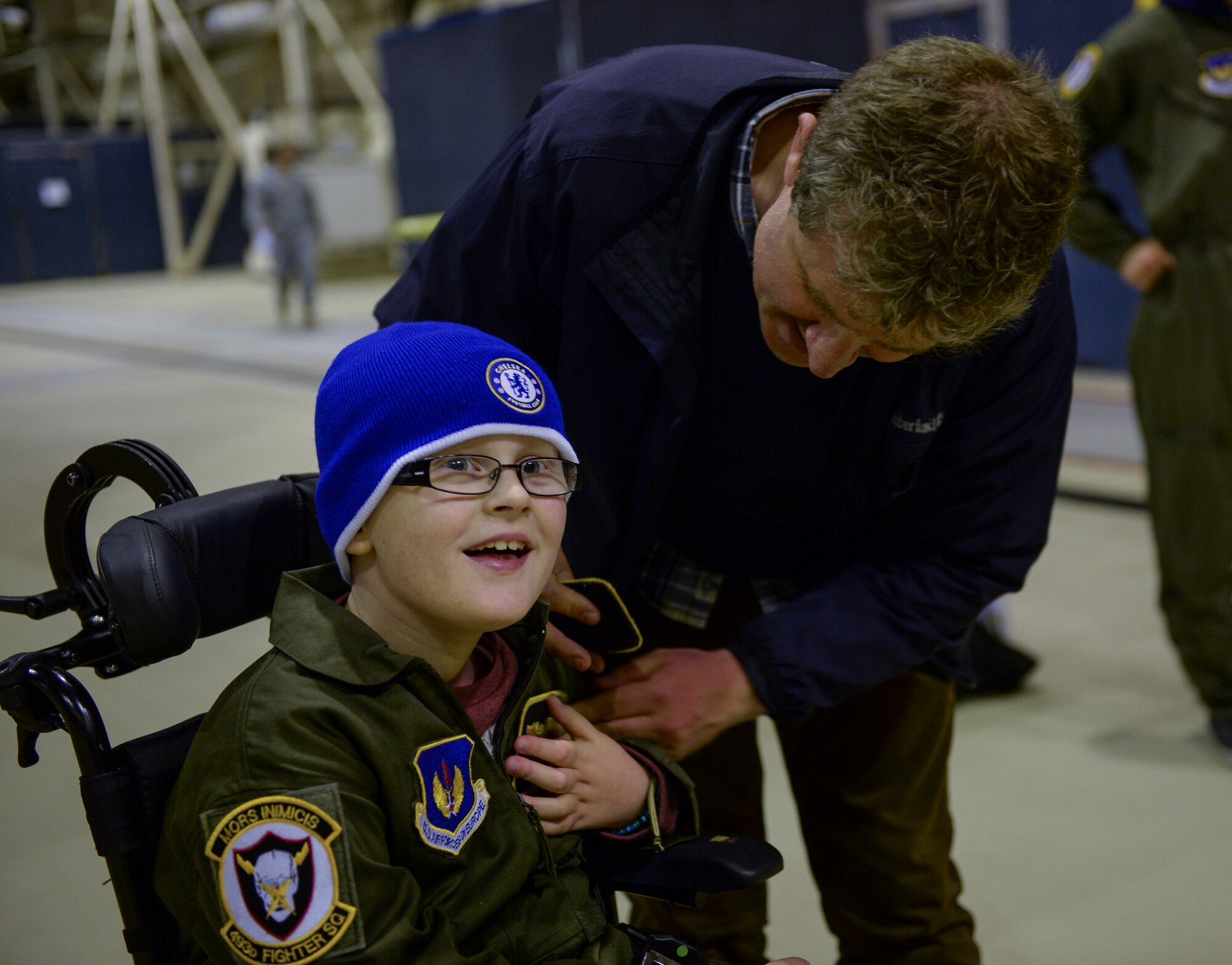 Pilot for a Day participant Ethan Ridd receives an honorary pilot’s wings nameplate at Hangar 7 on Royal Air Force Lakenheath, England, Oct. 10, 2013. Pilot for a Day, started in 2012, gives local children with serious illnesses a day away from routine hospital visits to see the Air Force. (U.S. Air Force photo by Airman 1st Class Nigel Sandridge/Released))