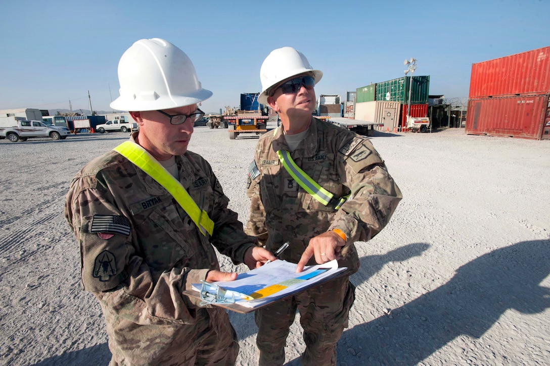 U.S. Army Sgt. 1st Class John Kramer, right, and U.S. Army Spc. David Bryan verify numbers on the data plate of a container for the International database on Kandahar Airfield, Afghanistan, Oct. 9, 2013. Kramer is assigned to the South Dakota Army National Guard's 152nd Combat Sustainment Support Battalion and Bryan is assigned to the North Carolina Army Reserves 846th Transportation Company.
