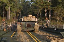 A M1A1A1 Abrams Main Battle Tank from 2nd Tank Battalion, 2nd Marine Division is guided off the raft made up of improved ribbon bridges by a combat engineer with Bridge Company, 8th Engineer Support Battalion, 2nd Marine Logistics Group during a tank crossing aboard Camp Lejeune, N.C., Oct. 17, 2013. Rafts are capable of carrying up to 150 tons, the weight of two M1A1A1 Abrams Main Battle Tanks, the heaviest piece of ground equipment the Marine Corps owns. (Photo by Lance Cpl. Shawn Valosin)