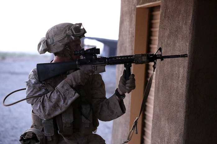 Private First Class Tony Richardson, a rifleman with Animal Company, 1st Battalion, 7th Marine Regiment, and a native of Milwaukee, holds an M16A4 service rifle at the ready position during a raid exercise here, Oct. 9, 2013. The Animal Co. Marines inserted into a training town by fast roping from UH-1Y Huey helicopters and engaged enemy role players while a designated team captured a suspected high-ranking insurgent. More than 20 Marines in the company were designated as enemy combatants and set up traps and obstacles throughout the town to challenge the assaulting Marines.