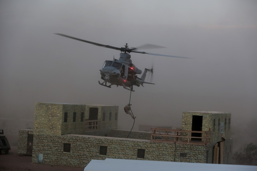 A Marine with Animal Company, 1st Battalion, 7th Marine Regiment, fast ropes from a UH-1Y Huey helicopter during a raid exercise here, Oct. 9, 2013. The Animal Co. Marines inserted into a training town by fast roping from the helicopters and engaged enemy role players while a designated team captured a suspected high-ranking insurgent. The company conducted the raid as part of the Weapons and Tactics Instructor Course in preparation for their deployment to Afghanistan this spring.