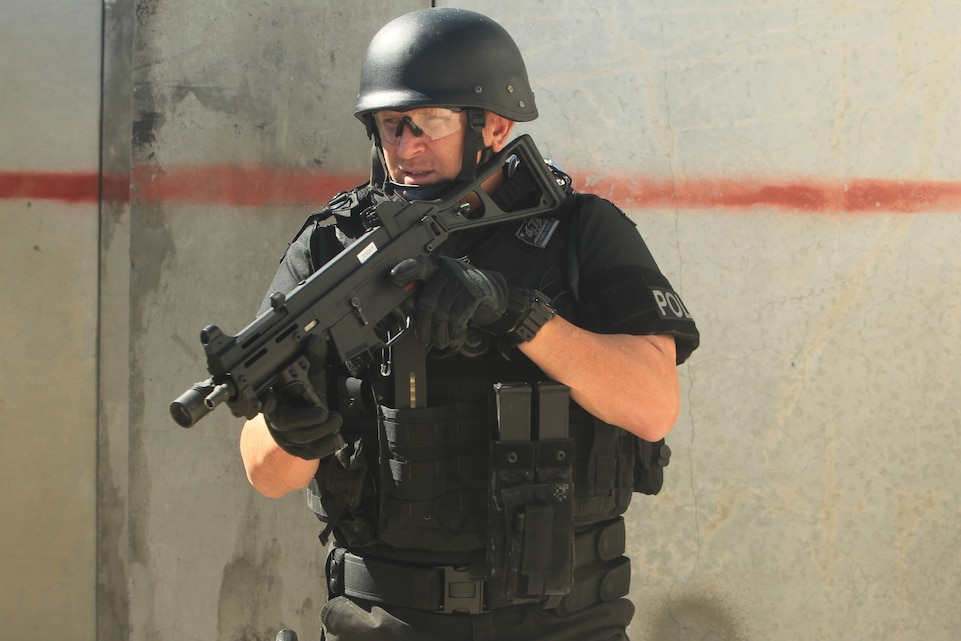 A SWAT team member with the Garden Grove Police Department practices room-clearing during a collaborated training exercise with the Provost Marshal's Office Special Reaction Team at Range 111 aboard the Combat Center Oct. 11, 2013.