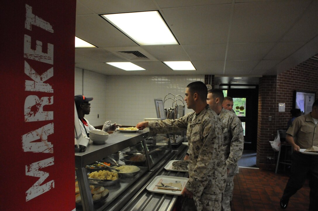 Sgt. Sergio Montes picks up food from the Bruce Hall “market” line during lunch on Oct. 3. The market theme is part of the menu overhaul that has brought more diners into Bruce Hall in recent months. 