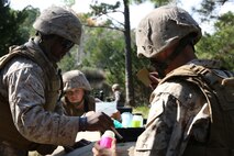 Water purification specialists with with Combat Logistics Battalion 24, Combat Logistics Regiment 27, 2nd Marine Logistics Group patch a hole in a 500-gallon water bladder during a battalion exercise aboard Camp Lejeune, N.C., Oct. 17, 2013. The Marines used the exercise as an opportunity to train with the Lightweight Water Purification System and support Landing Support Platoon, CLB-24 during helicopter support team operations.