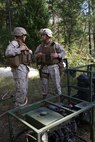 1st Lt. Justin D. Atkins [left], an engineer officer with Combat Logistics Battalion 24, Combat Logistics Regiment 27, 2nd Marine Logistics Group, speaks with Maj. Chad E. Roberts [right], the executive officer of CLB-24, about the role of water purification specialists during a battalion exercise aboard Camp Lejeune, N.C., Oct. 17, 2013. The specialists cleaned 500 gallons of water to be used by Landing Support Platoon, CLB-24 during helicopter support team air-lift operations. 