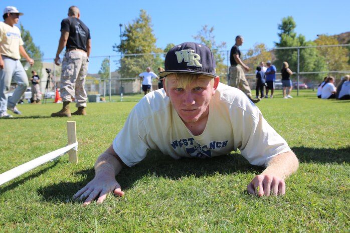 Chase Malynn,  junior varisty baseball player for West Ranch High School, gets in the prone postion to begin his maneuver under fire portion of the Combat Fitness Challenge at the West Ranch High School, Oct 1. The students ran what in the Marine Corps is called a Combat Fitness Test. It includes a 880-meter sprint, ammunition can lifts and manuever under fire. 