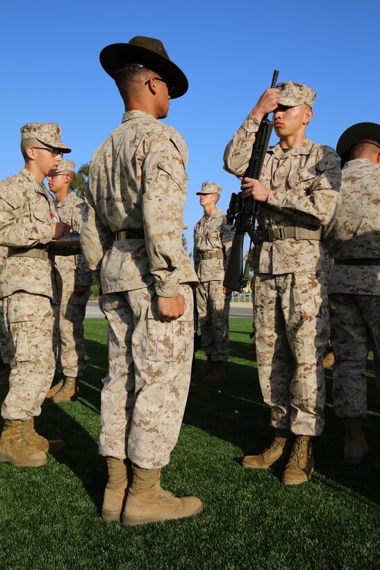 Recruits of Company H, 2nd Recruit Training Battalion, performs inspection arms as his drill instructor steps in front of him. Inspection arms is a rifle manual technique that shows the drill instructors that the recruits weapon is clear of any ammunition before passing it off to them.