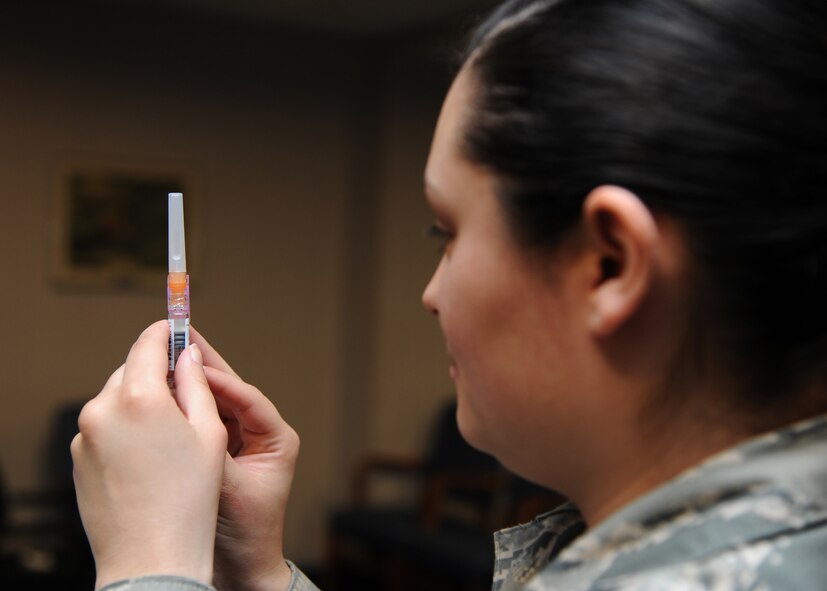 Staff Sgt. Cecily Yandell, 2nd Medical Group immunizations technician, removes an air bubble from an influenza shot at the General Dougherty Conference Center on Barksdale Air Force Base, La. Oct. 18, 2013. The 2nd MDG gives flu shots to individuals who are high-risked and do not meet the requirements to receive an nasal mist. (U.S. Air Force photo/Senior Airman Joseph A. Pagán Jr.)