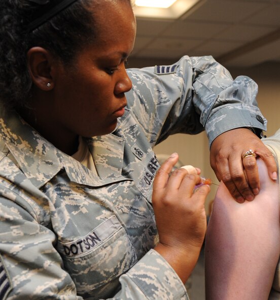 Staff Sgt. Robrielle Dotson, 2nd Medical Group immunizations technician, gives Staff Sgt. Katherine Holt, 2nd Bomb Wing Public Affairs photojournalist, an influeza shot at the General Dougherty Conference Center on Barksdale Air Force Base, La., Oct. 18, 2013. Airmen from the 2nd MDG are doing a road show for each squadron which helps keep all Department of Defense members from waiting in line at the medical clinic. (U.S. Air Force photo/Senior Airman Joseph A. Pagán Jr.)