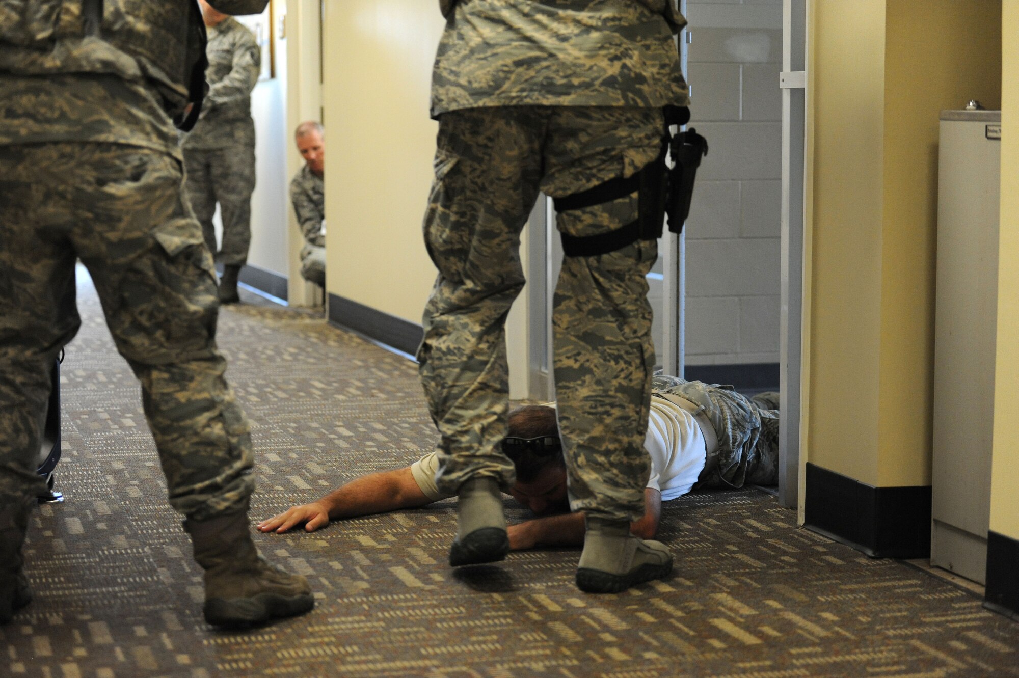 Staff Sgt. Bryant Horton, 85th Engineering Installation Squadron, is brought down by 81st Security Forces Squadron defenders during an active shooter exercise Oct 17, 2013, Keesler Air Force Base, Miss. The active shooter exercise was the first of its kind to prepare the 85th EIS compound for the 81st Security Forces Squadron’s response time during a real world incident. (U.S. Air Force photo by Airman 1st Class Stephan Coleman)