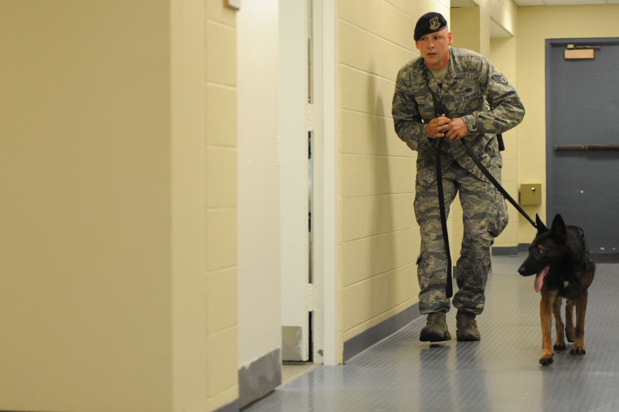Staff Sgt. James Wader, 81st Security Forces Squadron, leads his military working dog, Toki, through Maltby Hall during an active shooter exercise at the 85th Engineering Installation Squadron compound Oct 17, 2013, Keesler Air Force Base, Miss. The active shooter exercise was the first of its kind to prepare the 85th EIS compound for the 81st Security Forces Squadron’s response time during a real world incident. (U.S. Air Force photo by Airman 1st Class Stephan Coleman)