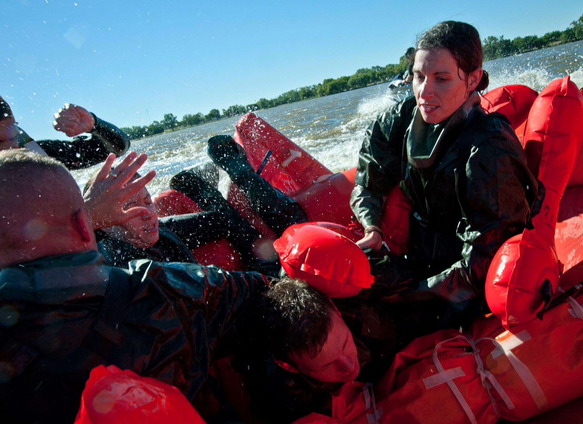 Staff Sgt. Jessica Lockoski, 22nd Air Refueling Wing Public Affairs NCO in charge, hauls Capt. Jesse Prater, 344th Air Refueling Squadron pilot, onboard a MB-1 20-man life raft Oct. 8, 2013, in Augusta, Kan. Survival, evasion, resistance and escape refresher training, required every three years, includes a water survival course that covers egress procedures and survival techniques in the event of an emergency landing in water.  (U.S. Air Force photo/Airman 1st Class Victor J. Caputo)