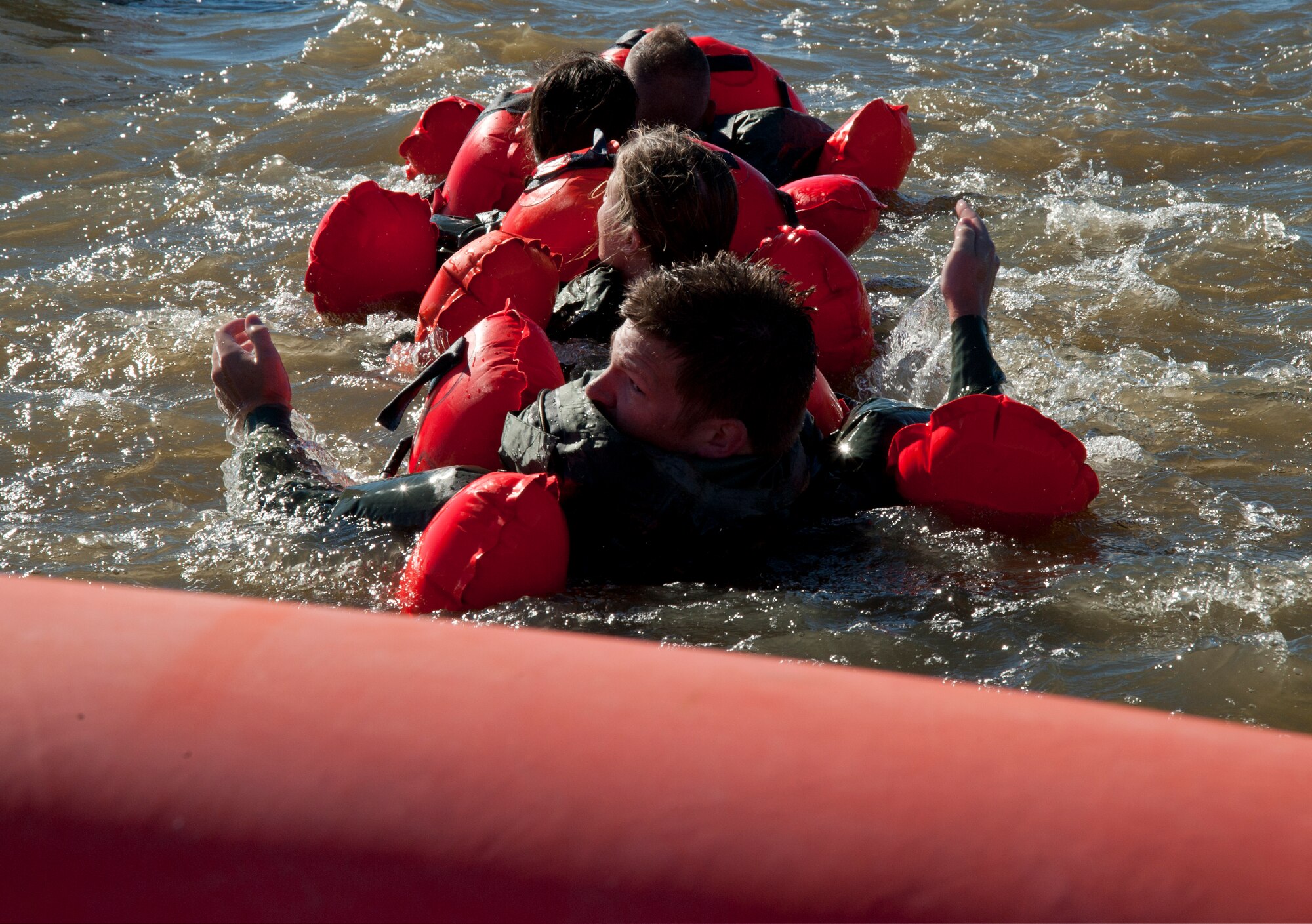 Capt. Jesse Prater, 344th Air Refueling Squadron pilot, looks for the life raft as he and several other Airmen swim while “chained up” Oct. 8, 2013, at McConnell Air Force Base, Kan. This maneuver is designed to provide maximum swimming efficiency in the water while keeping survivors together. Airmen were participating in a water survival course, part of their mandatory survival, evasion, resistance and escape refresher training. (U.S Air Force photo/Airman 1st Class Victor J. Caputo)