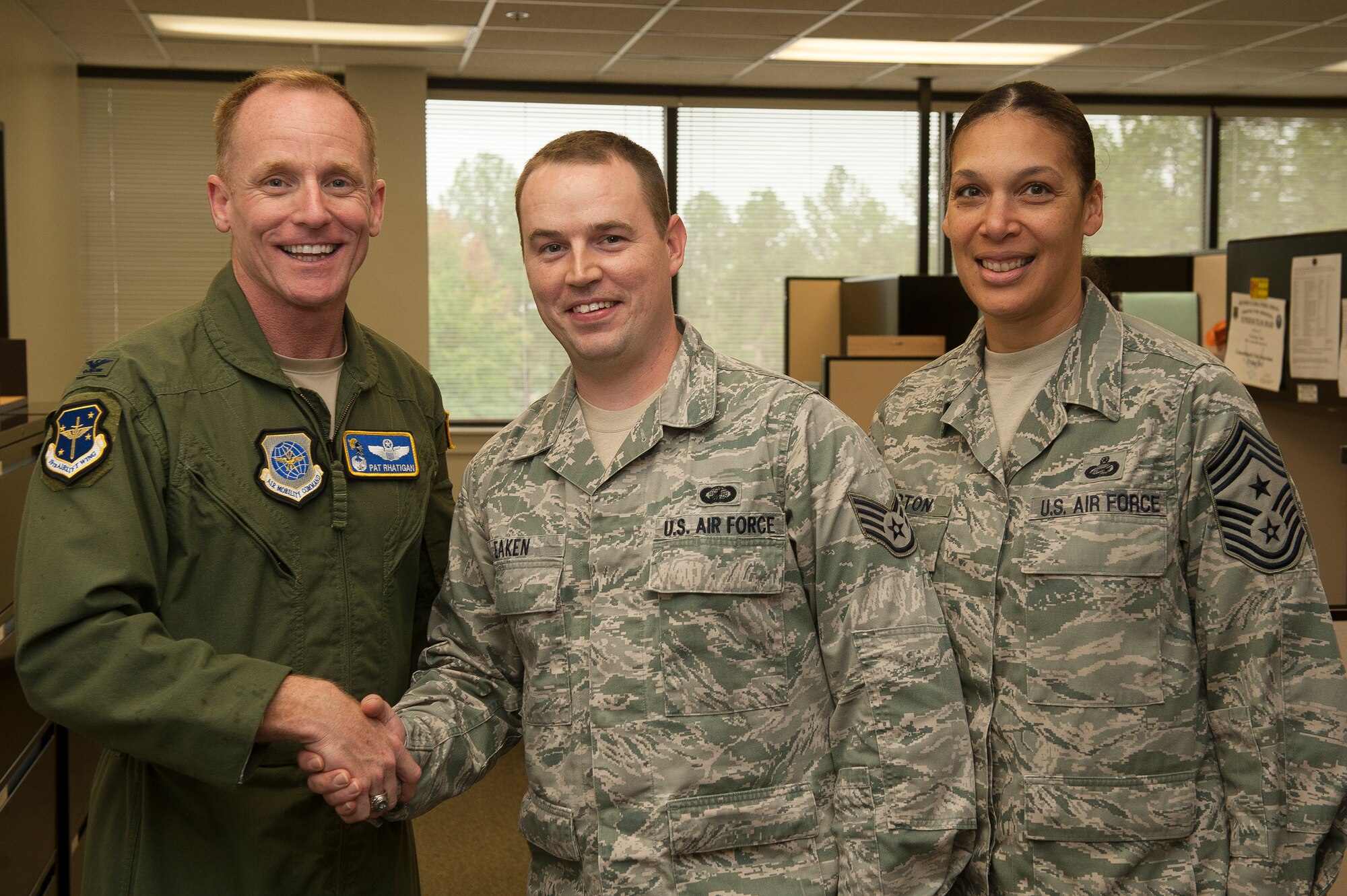 Col. Patrick Rhatigan, 19th Airlift Wing commander, and Chief Master Sgt. Margarita Overton, 19th Airlift Wing command chief, congratulate Staff Sgt. Timothy Eaken for his selection as Combat Airlifter of the Week Oct. 15, 2013, at Little Rock Air Force Base, Ark. Eaken was recognized for identifying and correcting a $600,000 error and ultimately collecting $2.3 million for the 19th Airlift Wing. (U.S. Air Force photo by Staff Sgt. Russ Scalf)