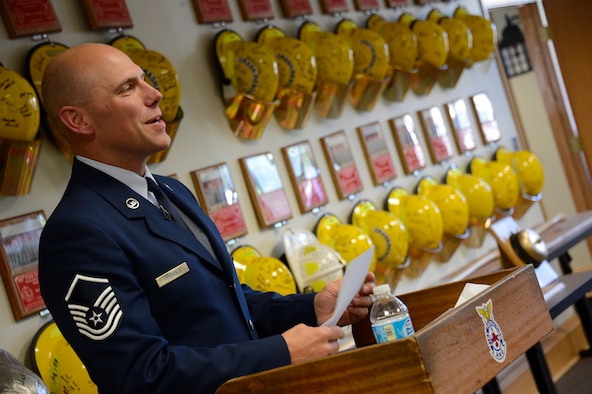 Amid a backdrop of memorial plaques and helmets honoring their members, Master Sgt. Mark Legvold, base fire chief, prepares for the closing ceremony of the 133rd Fire Department on Sept 22.  The ceremony honored firefighters from the past and present and were able to reflect not only on their heritage of service, but on the human aspect of the cuts the military has faced in 2013.  (U.S. Air National Guard photo by Tech. Sgt. Lynette Olivares/ Released)