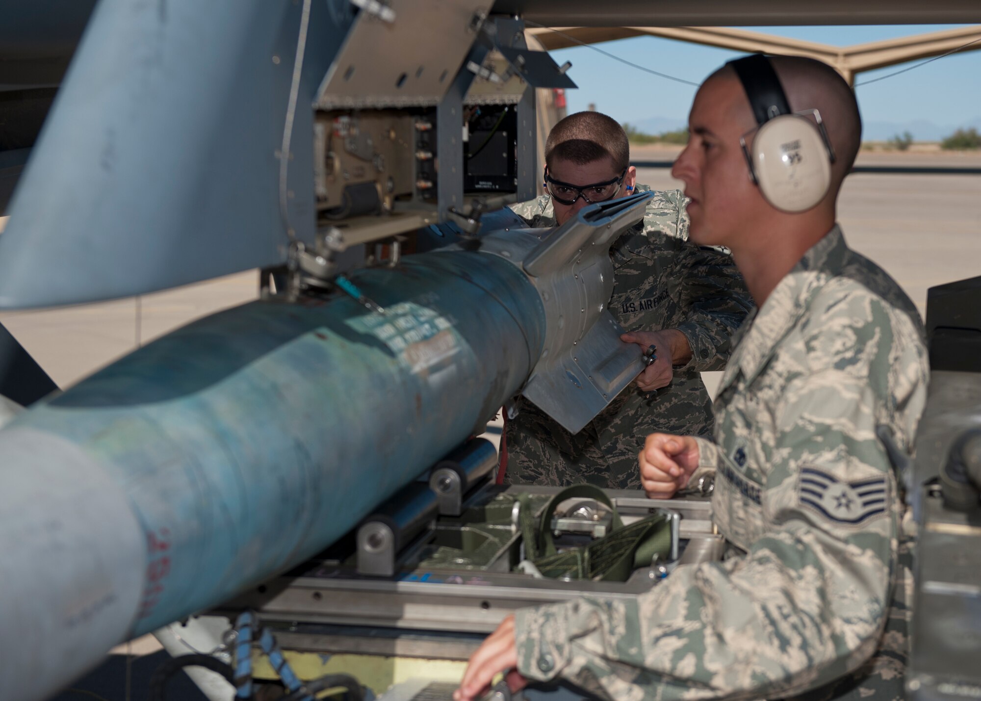 Airman 1st Class Robert Lawrence and Staff Sgt. Jonathan Adams, 849th Aircraft Maintenance Squadron weapons load crew, load an inert missile during the quarterly load crew competition at Holloman Air Force Base, N.M., Oct. 11. The MQ-9 Reaper load crew competed to have their skills evaluated alongside the F-22 Raptor and German Air Force Tornado load crews. For the competition, points were awarded for weapons loading, tool kit inspection and uniform inspection. (U.S. Air Force photo by Airman 1st Class Aaron Montoya/Released)