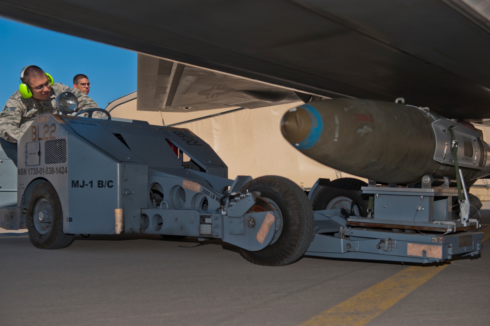 Senior Airman Alec Anguiano, 49th Aircraft Maintenance Squadron weapons load crew, loads an inert bomb during the quarterly load crew competition at Holloman Air Force Base, N.M., Oct. 11. The F-22 Raptor load crew competed to have their skills evaluated alongside MQ-9 Reaper and German Air Force Tornado load crews. For the competition, points were awarded for weapons loading, tool kit inspection and uniform inspection. (U.S. Air Force photo by Airman 1st Class Aaron Montoya/Released)