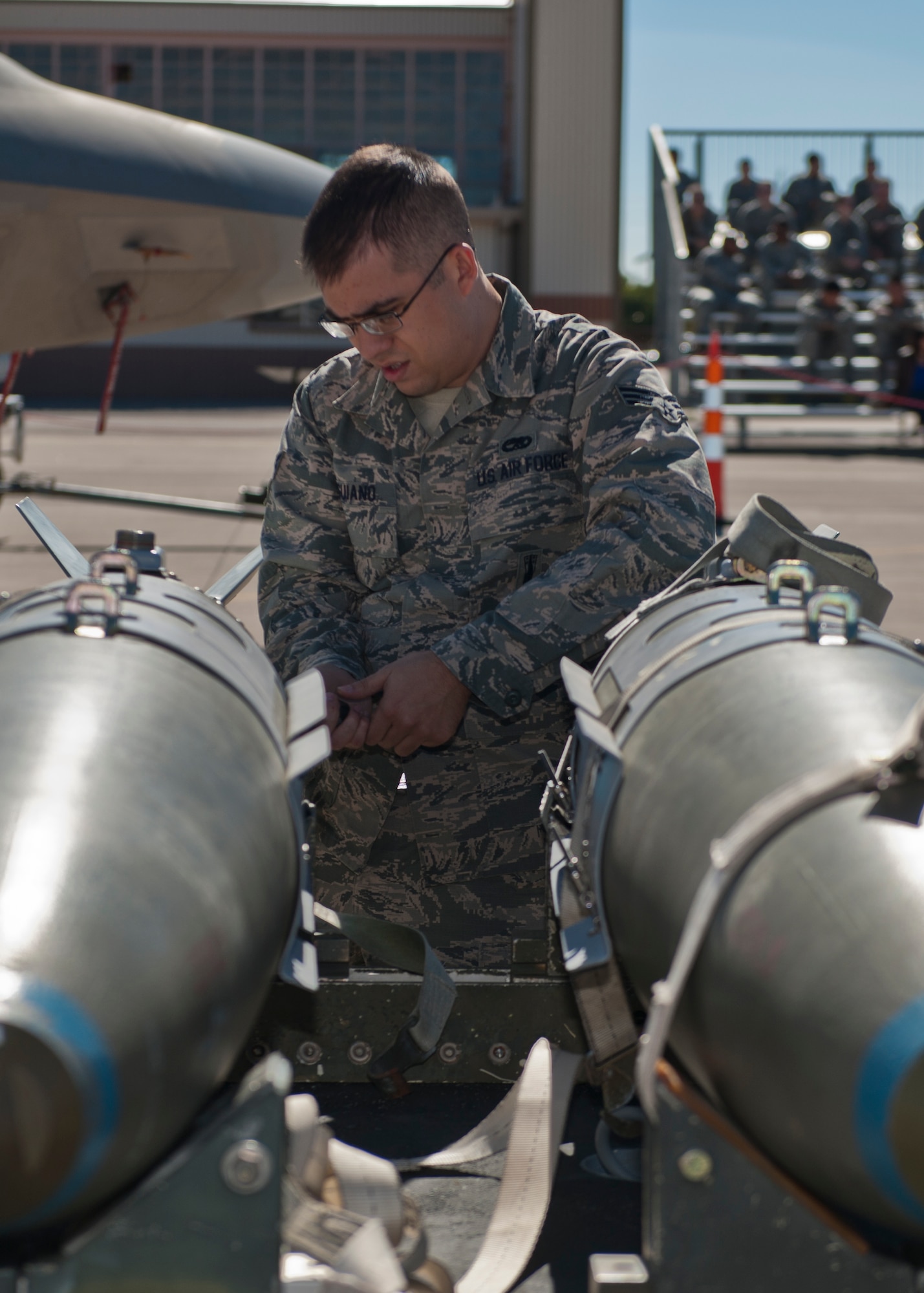 Senior Airman Alec Anguiano, 49th Aircraft Maintenance Squadron weapons load crew, unloads an inert bomb during the quarterly load crew competition at Holloman Air Force Base, N.M., Oct. 11. The F-22 Raptor load crew competed to have their skills evaluated alongside MQ-9 Reaper and German Air Force Tornado load crews. For the competition, points were awarded for weapons loading, tool kit inspection and uniform inspection. (U.S. Air Force photo by Airman 1st Class Aaron Montoya/Released)