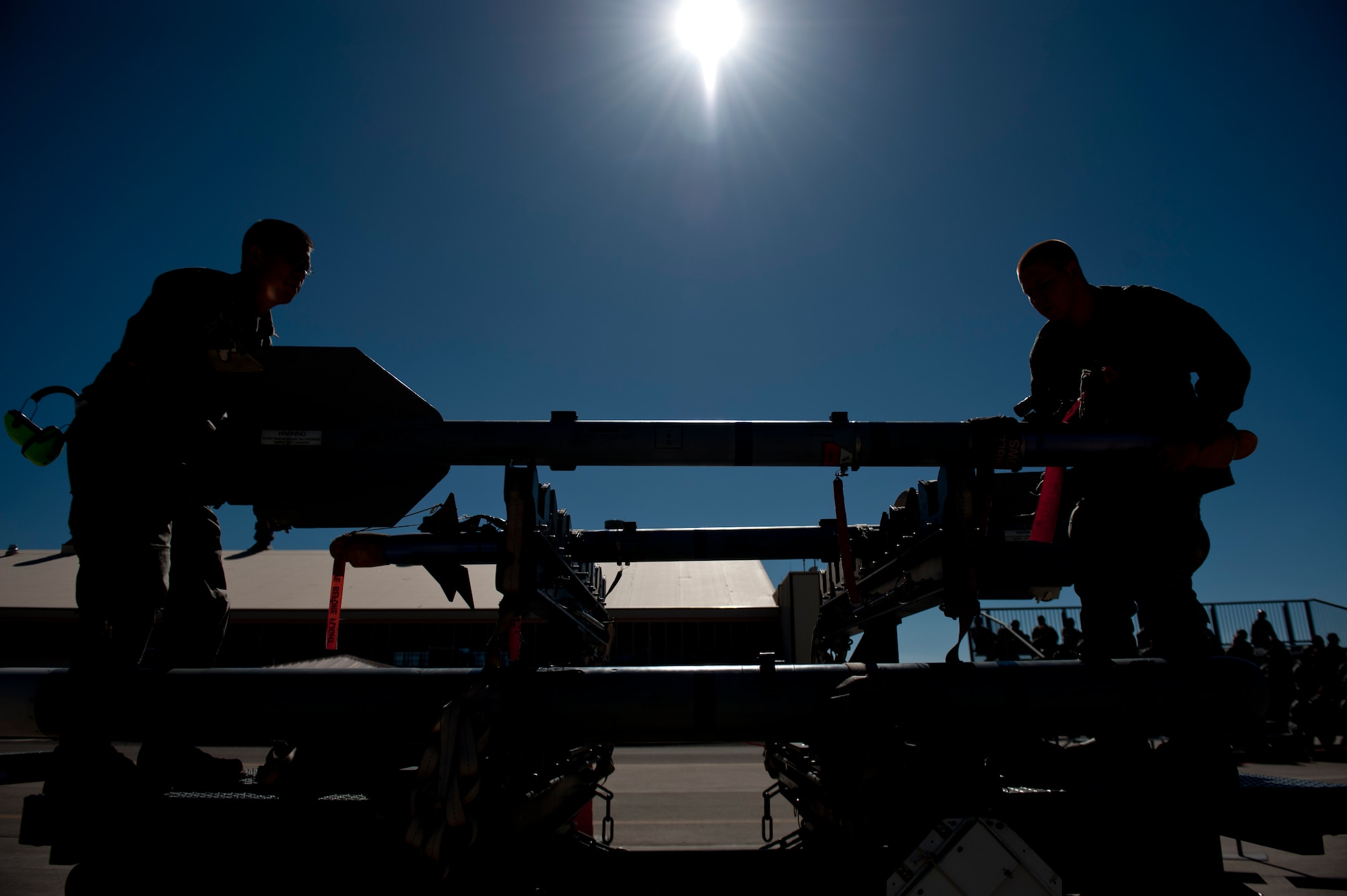 Senior Airman Alec Anguiano and Senior Airman Jonathan Strait, 49th Aircraft Maintenance Squadron weapons load crew, unload an inert missile during a quarterly load crew competition at Holloman Air Force Base, N.M., Oct. 11. The F-22 Raptor load crew competed to have their skills evaluated alongside MQ-9 Reaper and German Air Force Tornado load crews. For the competition, points were awarded for weapons loading, tool kit inspection and uniform inspection. (U.S. Air Force photo by Airman 1st Class Aaron Montoya/Released)