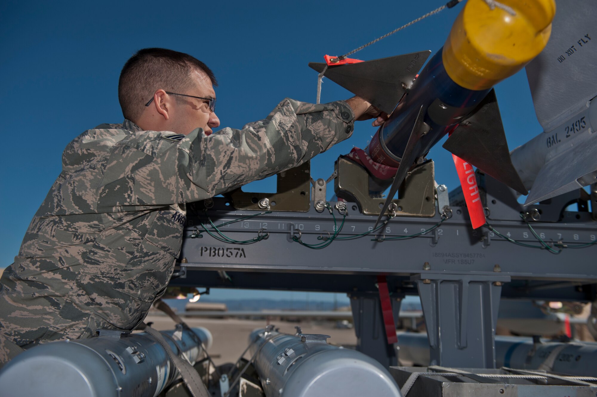 Senior Airman Alec Anquiano, 49th Aircraft Maintenance Squadron weapons load crew, unloads an inert missile during the quarterly load crew competition at Holloman Air Force Base, N.M., Oct. 11. The F-22 Raptor load crew competed to have their skills evaluated alongside MQ-9 Reaper and German Air Force Tornado load crews. For the competition, points were awarded for weapons loading, tool kit inspection and uniform inspection. (U.S. Air Force photo by Airman 1st Class Aaron Montoya/Released)