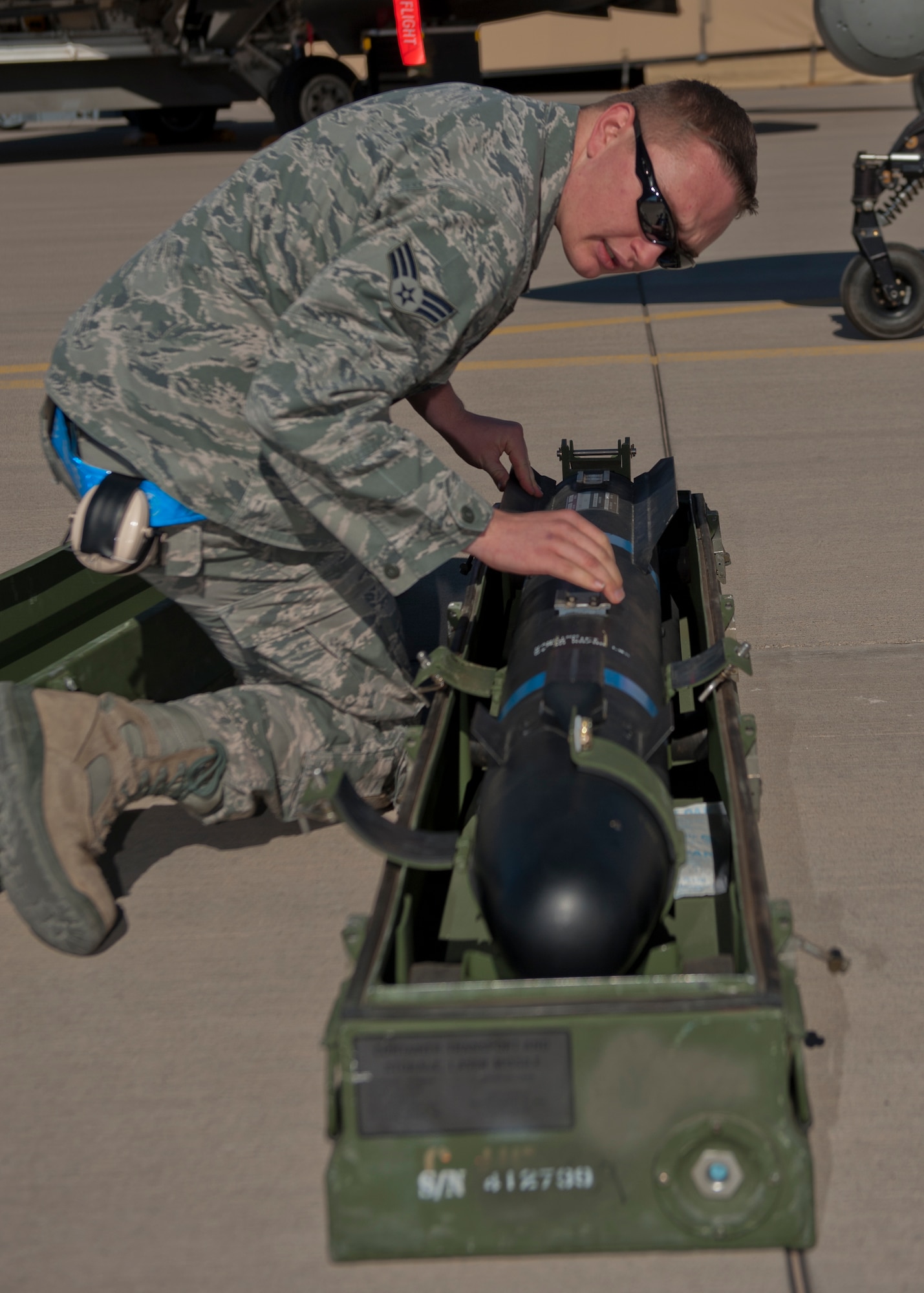 Senior Airman Edward Smigiel, 849th Aircraft Maintenance Squadron weapons load crew, checks an inert missile for damage during the quarterly load crew competition at Holloman Air Force Base, N.M., Oct. 11. The 849th AMXS pitted two MQ-1 Predator load crews against each other to evaluate who could prepare the aircraft for combat the quickest and with the fewest procedural errors. (U.S. Air Force photo by Airman 1st Class Aaron Montoya/Released)