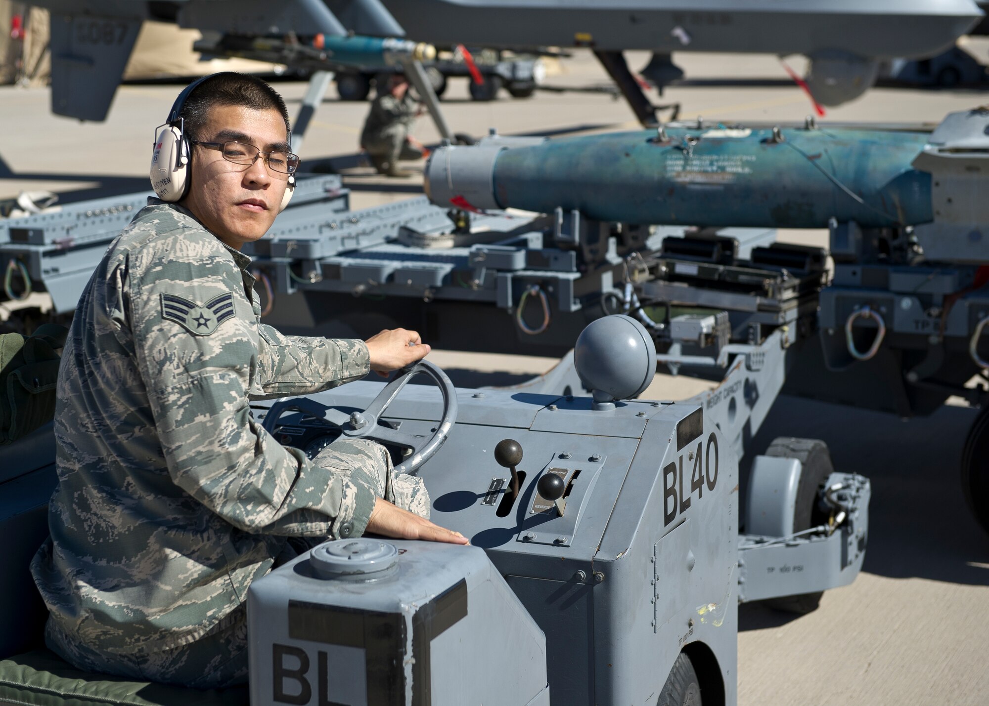 Senior Airman Binh Nguyen, a member of the 849th Aircraft Maintenance Squadron weapons load crew, prepares to load an inert missile during a quarterly load crew competition at Holloman Air Force Base, N.M., Oct 11. The MQ-9 Reaper load crew competed to have their skills evaluated alongside F-22 Raptor and the German Air Force Tornado load crews. For the competition, points were awarded for weapons loading, tool kit inspection and uniform inspection. (U.S. Air Force photo by Airman 1st Class Chase Cannon/Released)