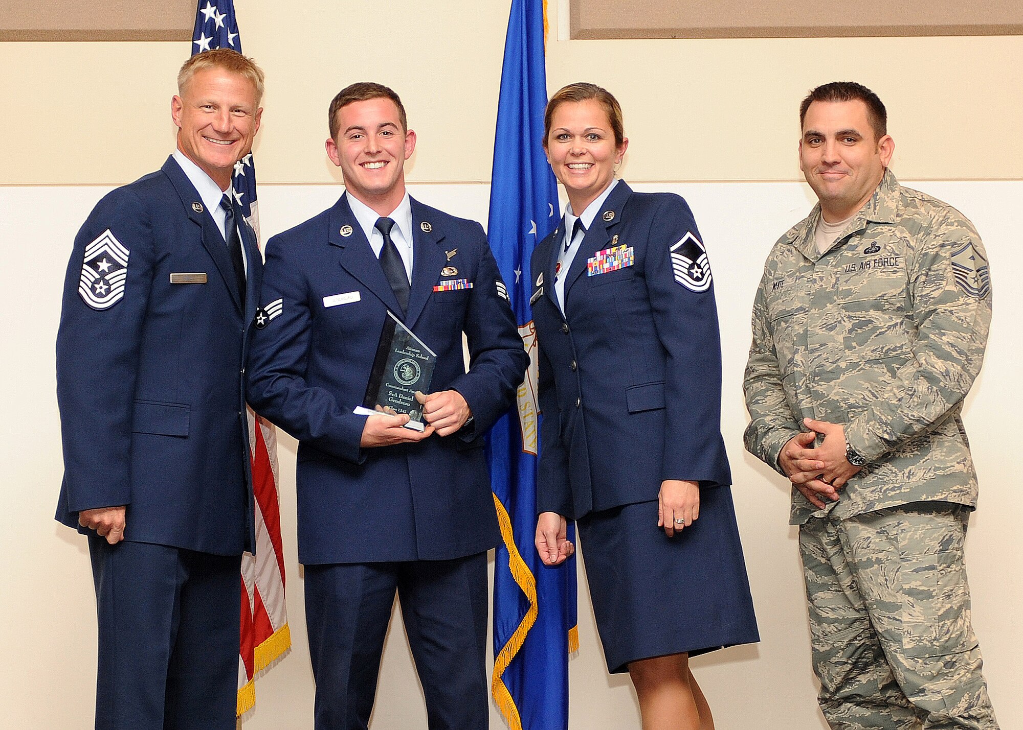 Senior Airman Daniel Gendreau, 566th Intelligence Squadron, second from left, receives the Commandant Award during the Buckley Airman Leadership School Class 13-G graduation Oct. 17, 2013, at the Leadership Development Center on Buckley Air Force Base, Colo. The award is presented to the student who displayed all the characteristics of an effective leader during ALS. (U.S. Air Force photo by Senior Airman Marcy Copeland/Released)