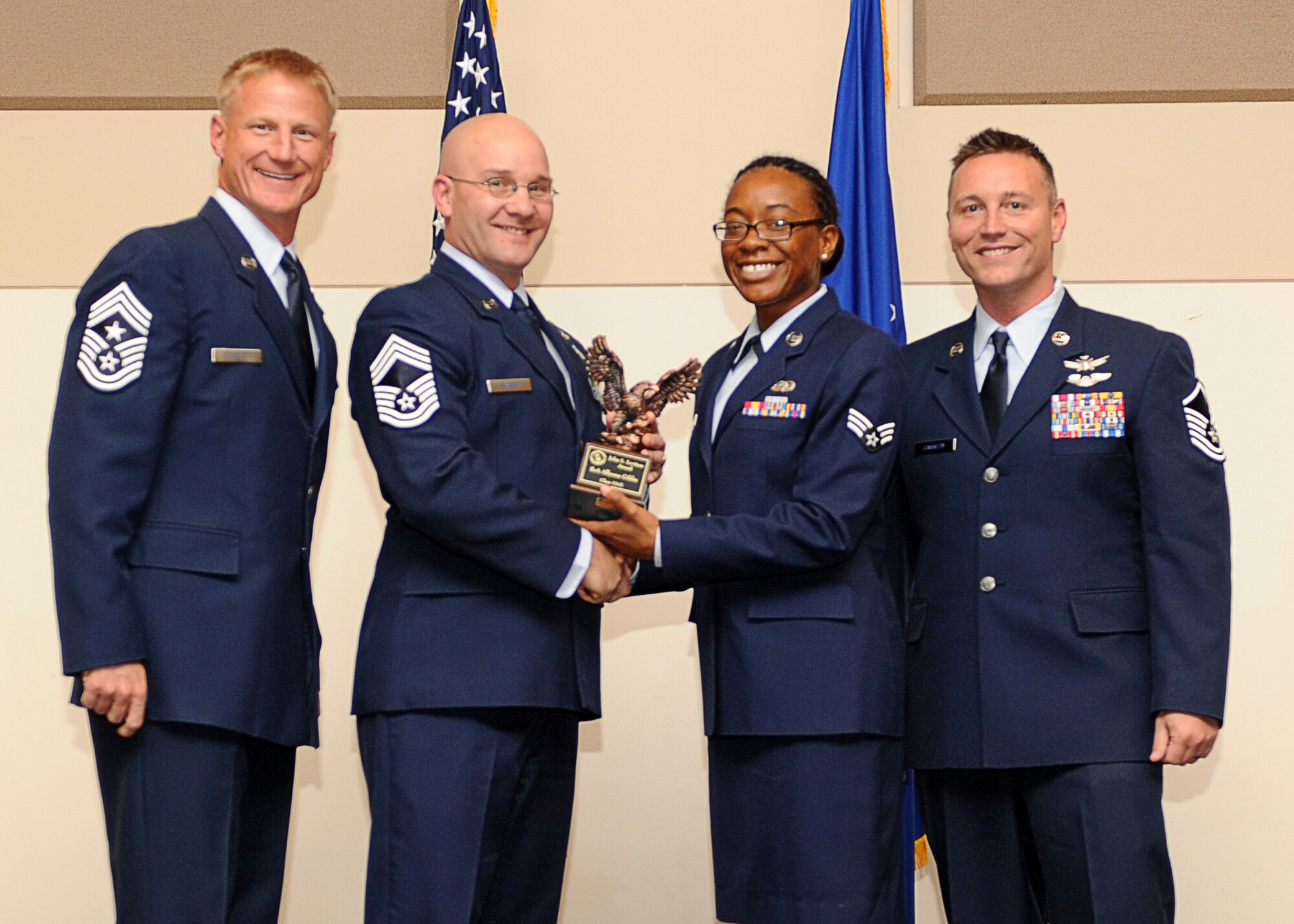 Senior Airman Allyana Gibbs, 460th Space Communications Squadron, second from right, receives the John L. Levitow Award during the Buckley Airman Leadership School Class 13-G graduation Oct. 17, 2013, at the Leadership Development Center on Buckley Air Force Base, Colo. The Levitow Award is presented to the student who demonstrated the most outstanding leadership and scholastic qualities. (U.S. Air Force photo by Senior Airman Marcy Copeland/Released)