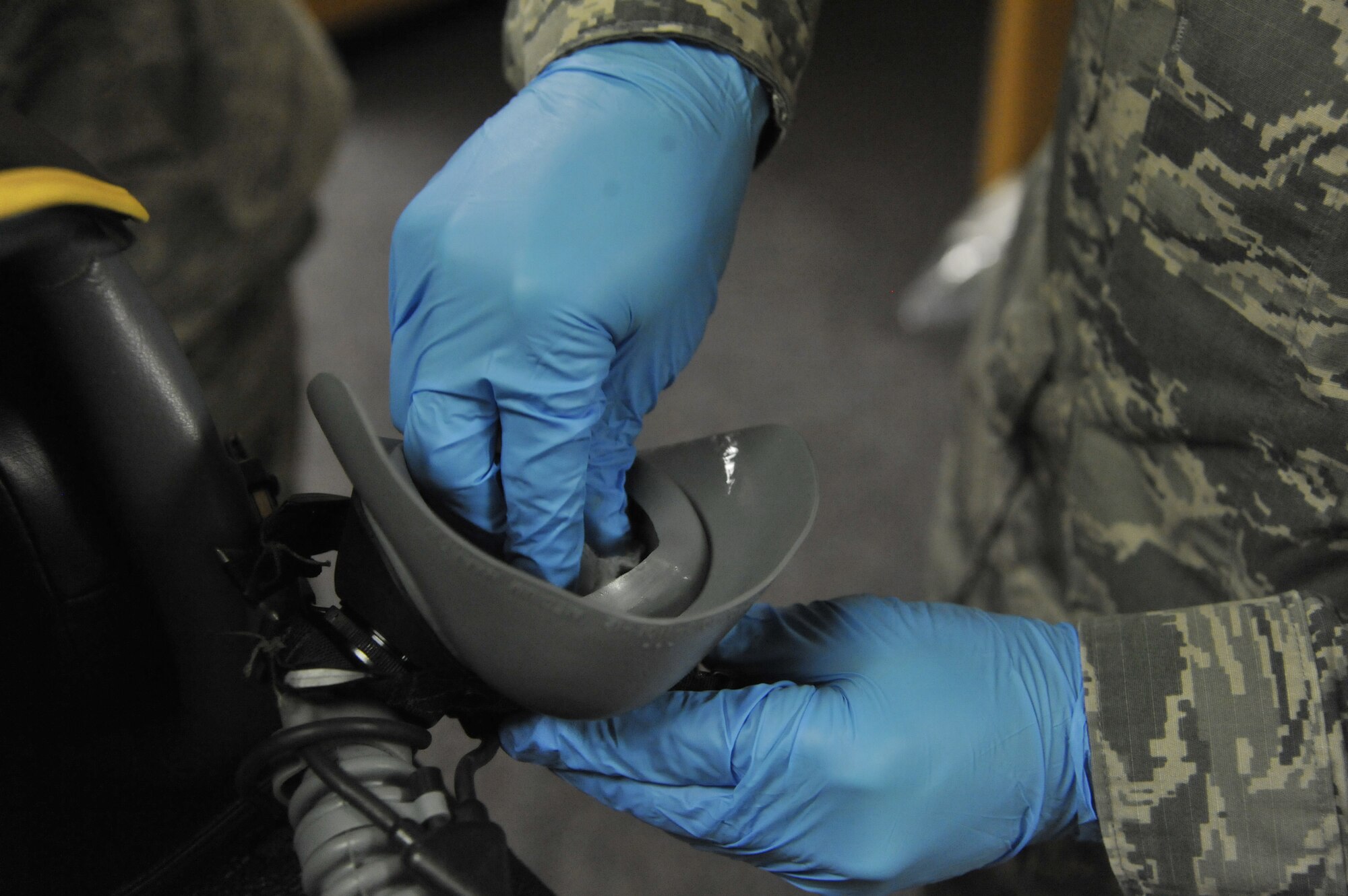 U. S. Air Force Senior Airman Steven Lee, 509th Operations Support Squadron aircrew flight equipment technician, cleans an MBU-20/P soft shell mask at Whiteman Air Force Base, Mo., Oct. 9, 2013. The mask conforms to the pilot’s face and allows the transfer of oxygen from outside the jet into the pilot’s lungs. (U.S. Air Force photo by Airman 1st Class Keenan Berry/Released)